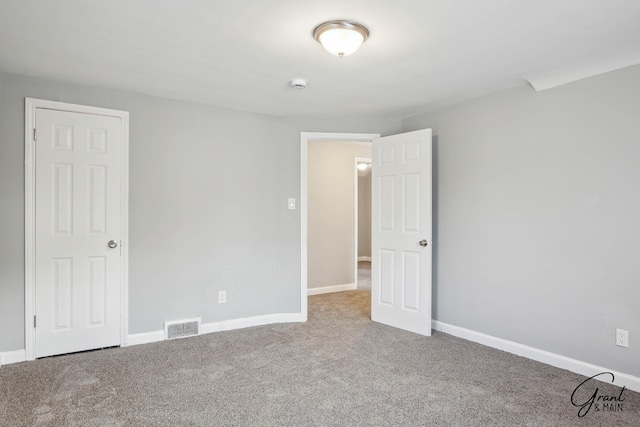 unfurnished bedroom featuring carpet, visible vents, and baseboards