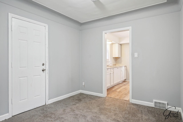 unfurnished room with baseboards, visible vents, and light colored carpet