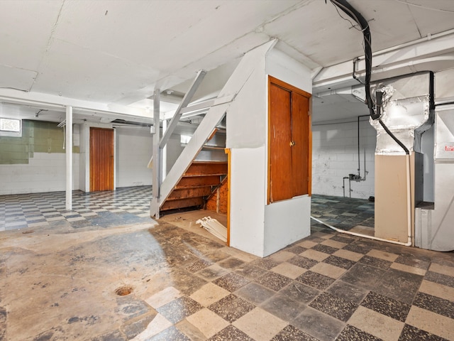 finished basement featuring concrete block wall and stairs