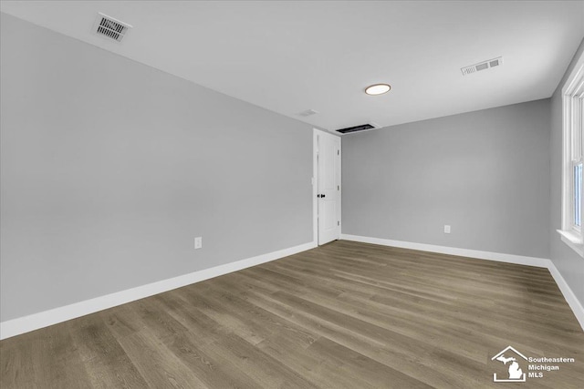 empty room with visible vents, baseboards, and wood finished floors