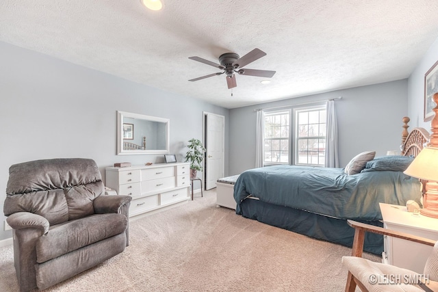 bedroom featuring a textured ceiling, a ceiling fan, and light colored carpet