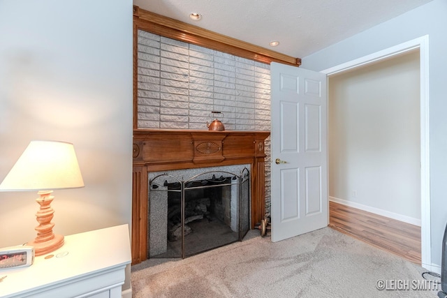 living room featuring light colored carpet, a textured ceiling, baseboards, and a premium fireplace