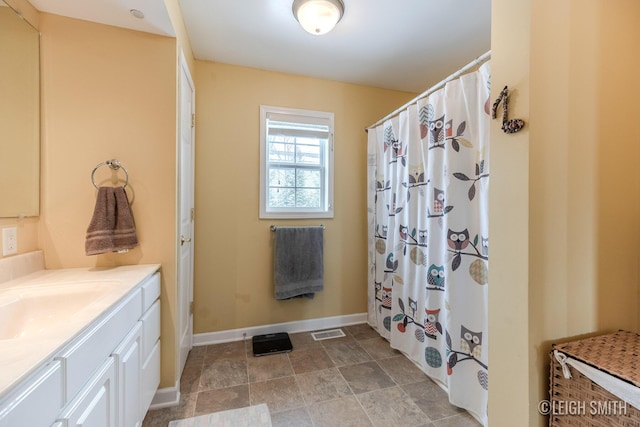 bathroom featuring a shower with curtain, vanity, visible vents, and baseboards