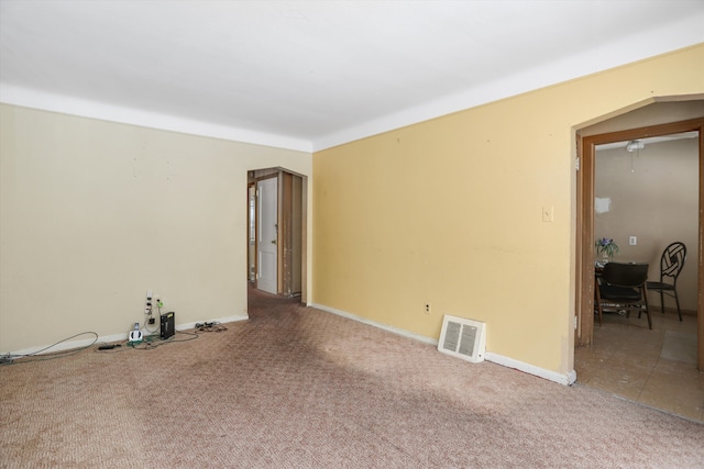 spare room featuring baseboards, visible vents, and carpet flooring