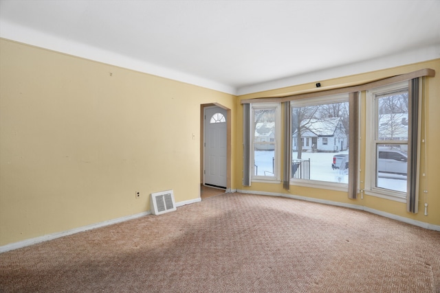 unfurnished room featuring carpet, visible vents, and baseboards