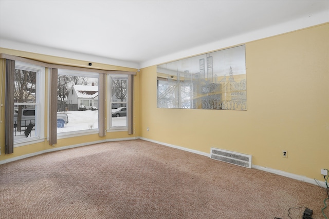 carpeted empty room featuring visible vents and baseboards