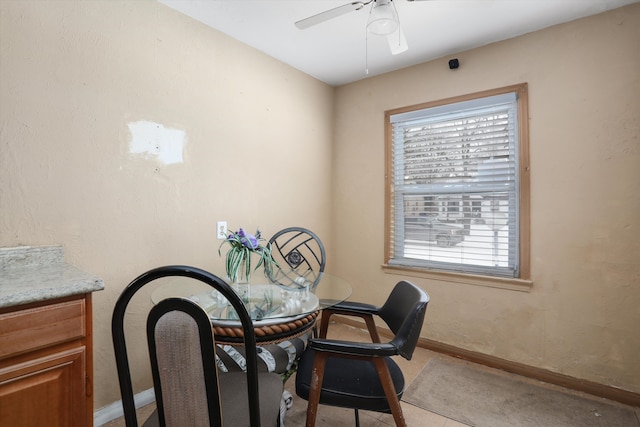 dining space featuring ceiling fan and baseboards