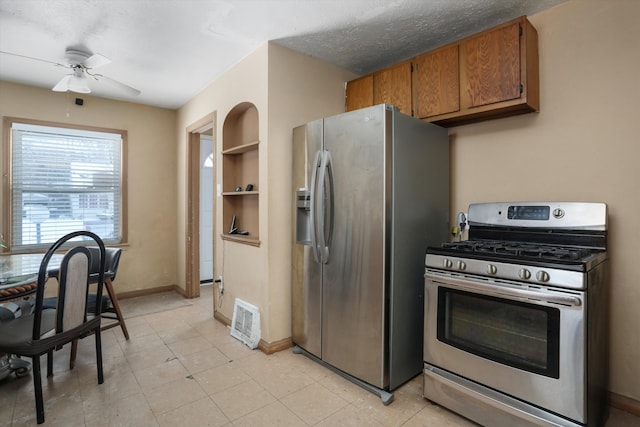 kitchen with brown cabinets, visible vents, appliances with stainless steel finishes, a textured ceiling, and baseboards