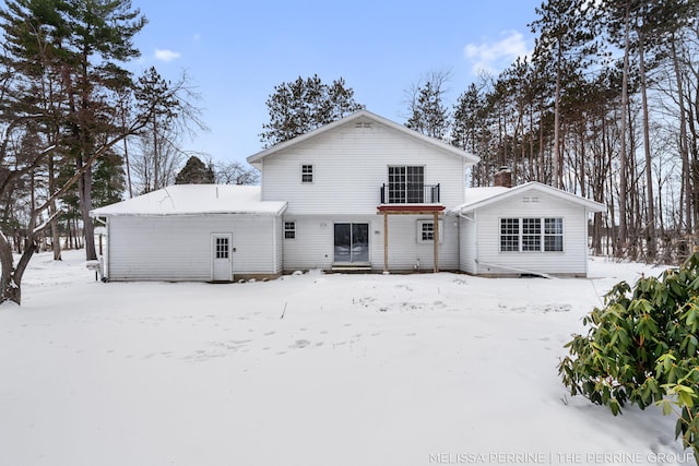 view of snow covered back of property