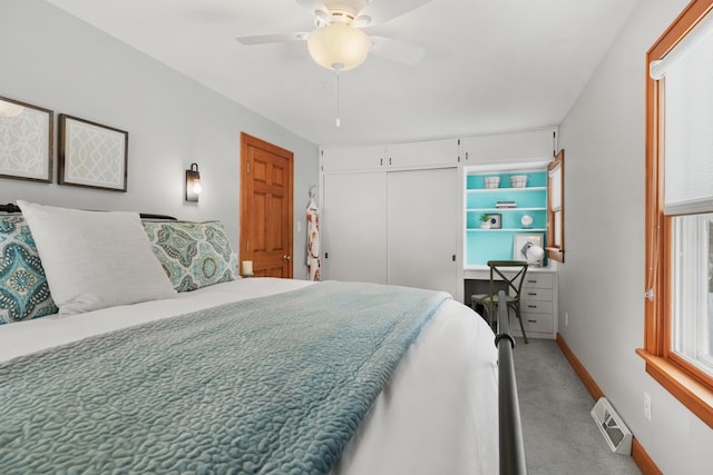 bedroom with light colored carpet, a ceiling fan, baseboards, visible vents, and a closet