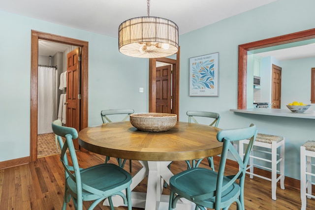 dining area featuring baseboards and wood finished floors