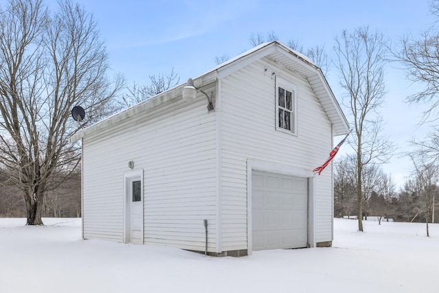 view of snowy exterior featuring a garage