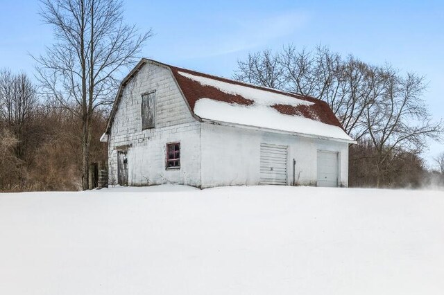 exterior space featuring a garage, an outdoor structure, a barn, and a gambrel roof