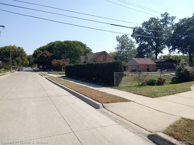 view of street with traffic signs, curbs, and sidewalks