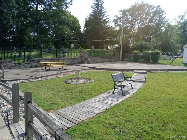 view of home's community with a patio, a lawn, and fence