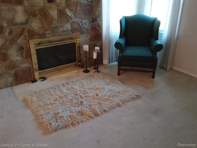 living area featuring carpet and a fireplace