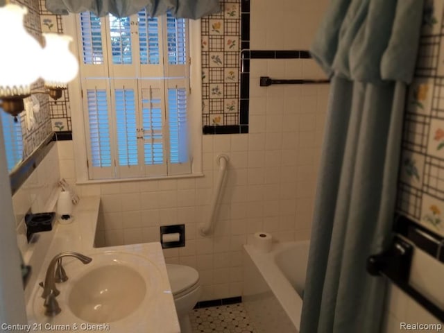 bathroom featuring a tub to relax in, toilet, a shower with shower curtain, a sink, and tile walls