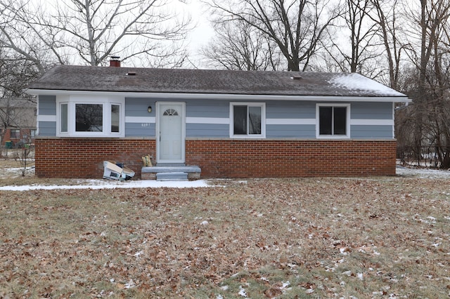 view of front of property with a chimney and brick siding