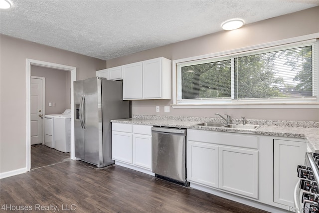6291 Edmund St, Romulus, MI 48174 - kitchen featuring stainless steel appliances, washer and clothes dryer, dark wood-style floors, white cabinetry, and a textured ceiling
