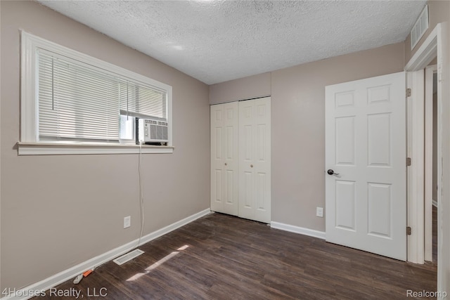6291 Edmund St, Romulus, MI 48174 - unfurnished bedroom featuring dark wood-style floors, a textured ceiling, a closet, and cooling unit