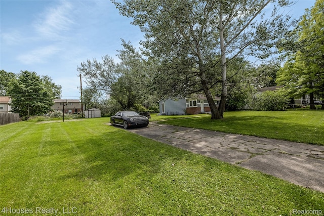 6291 Edmund St, Romulus, MI 48174 - view of green lawn with asphalt driveway and a storage shed