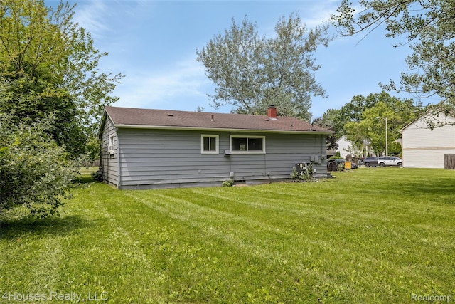 6291 Edmund St, Romulus, MI 48174 - back of property with a lawn and a chimney