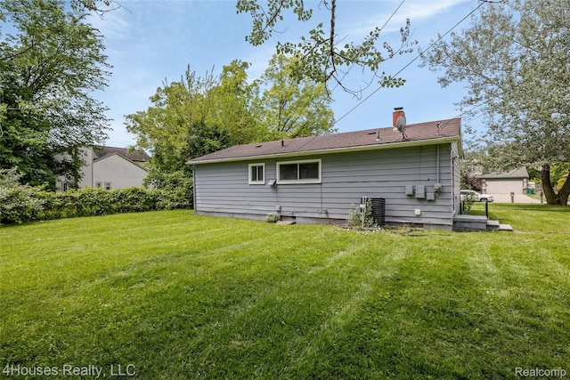 6291 Edmund St, Romulus, MI 48174 - rear view of property featuring a lawn and a chimney