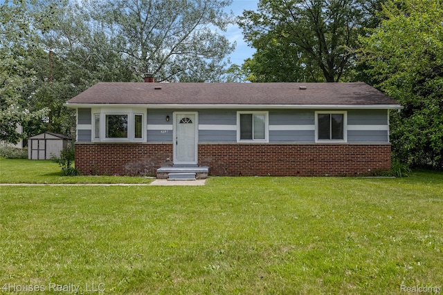 6291 Edmund St, Romulus, MI 48174 - view of front of home featuring a front lawn, brick siding, a storage shed, and a chimney