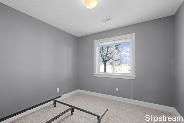 empty room featuring carpet flooring, visible vents, and baseboards