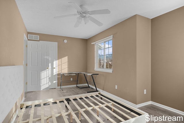 interior space featuring a ceiling fan, baseboards, visible vents, and wood finished floors