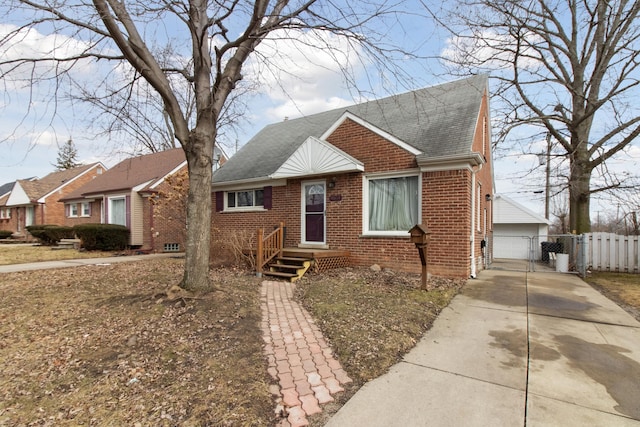 bungalow with a garage, brick siding, fence, roof with shingles, and a gate