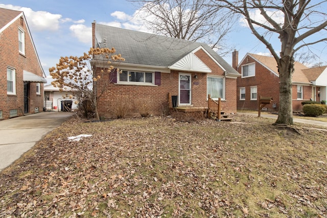 bungalow-style home featuring brick siding and a shingled roof