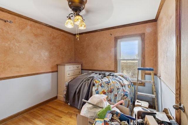 bedroom with light wood finished floors, baseboards, and ornamental molding