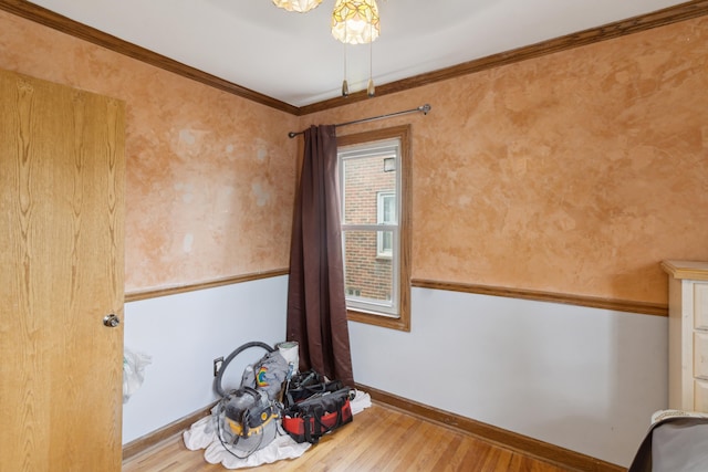 empty room featuring ornamental molding, wood finished floors, and baseboards