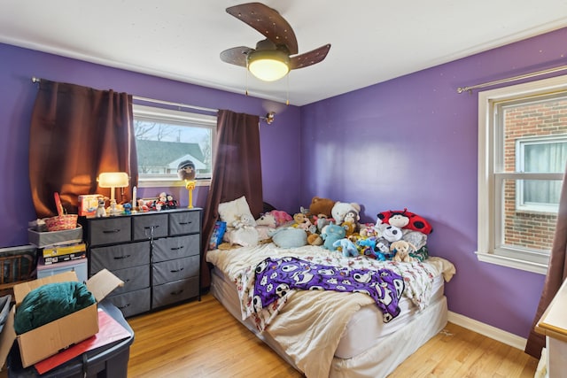 bedroom featuring ceiling fan, baseboards, and wood finished floors