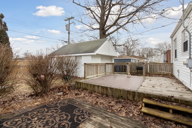 wooden terrace featuring fence, grilling area, and an outbuilding