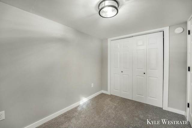 unfurnished bedroom with a closet, carpet flooring, and baseboards