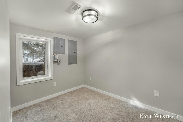 unfurnished room featuring carpet floors, baseboards, electric panel, and visible vents