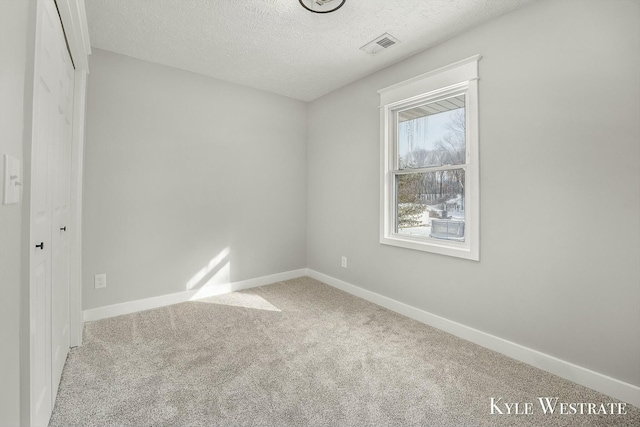 unfurnished bedroom featuring light carpet, visible vents, baseboards, and a textured ceiling