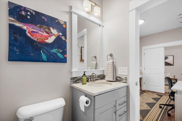 bathroom featuring tasteful backsplash, vanity, and toilet