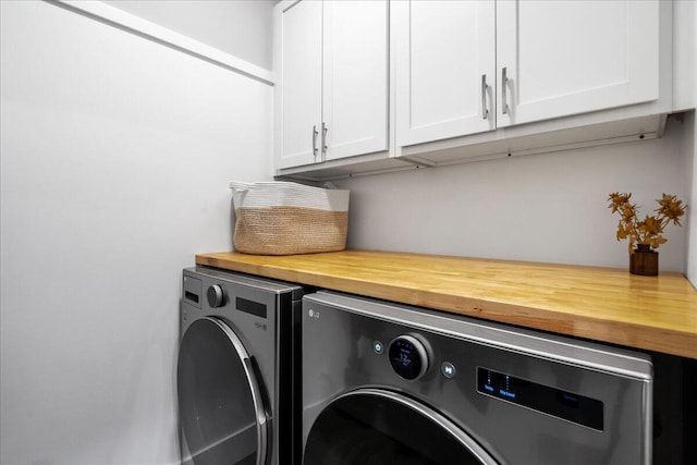 laundry room with washing machine and dryer and cabinet space