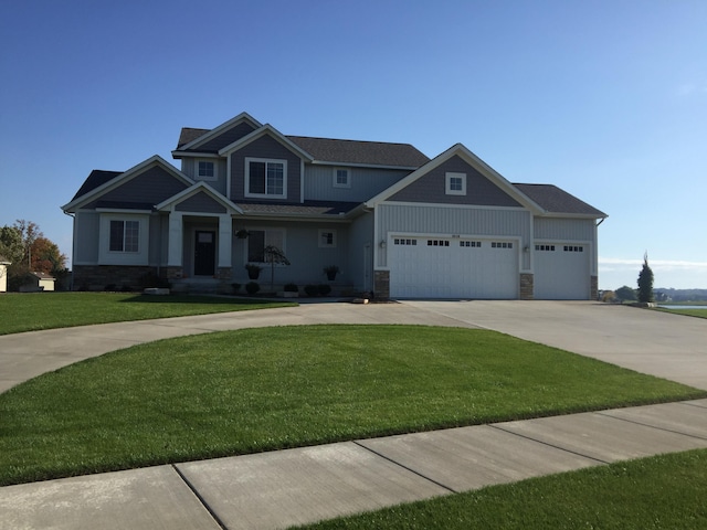 craftsman house featuring driveway, a garage, stone siding, a front lawn, and board and batten siding