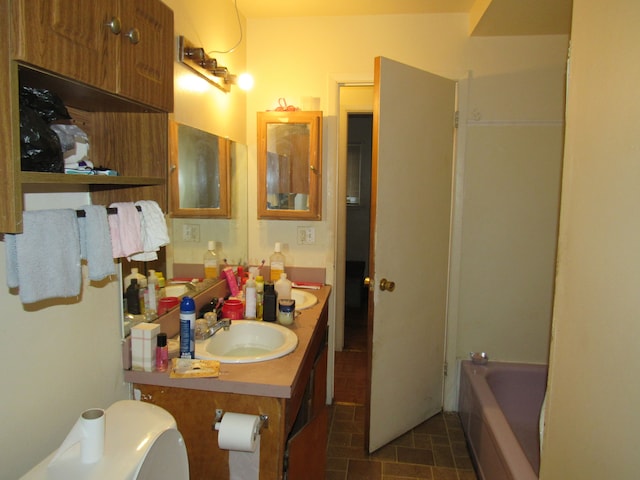 full bath with toilet, vanity, and a bathing tub