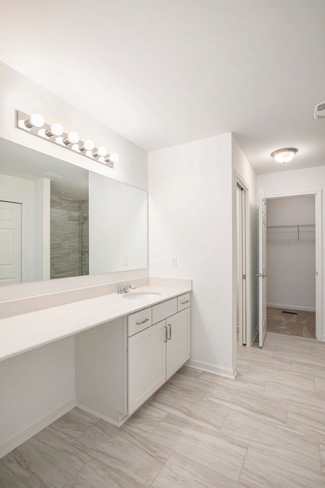 72180 Van Dyke, Bruce, MI 48065 - bathroom with a shower stall, vanity, a walk in closet, and baseboards