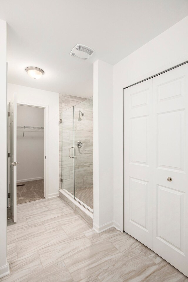 72180 Van Dyke, Bruce, MI 48065 - bathroom featuring a stall shower, baseboards, and a walk in closet