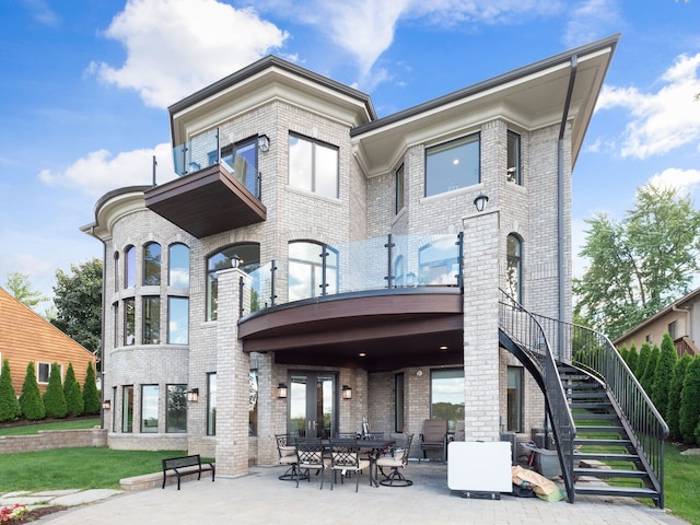 back of property with a patio area, brick siding, and stairs