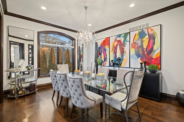 dining room with baseboards, visible vents, wood finished floors, and ornamental molding