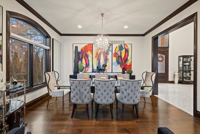 dining area with a chandelier, ornamental molding, baseboards, and wood finished floors