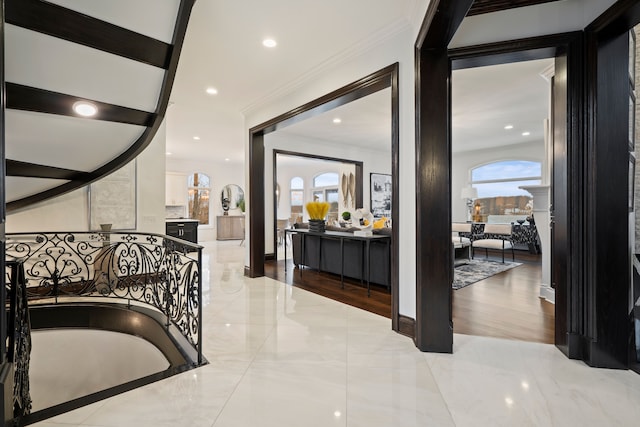 hallway with marble finish floor, ornamental molding, and recessed lighting