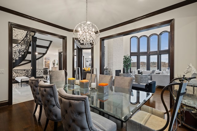 dining room featuring ornamental molding, wood finished floors, a notable chandelier, and stairs